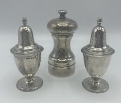 A pair of Adam style pepperettes together with a sterling silver pepper grinder.