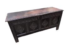 An oak, four panel coffer, the front panels carved with diamond pattern, and on four raised square