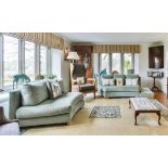 A pair of modern, olive green/blue upholstered curved shaped sofas and matching stools