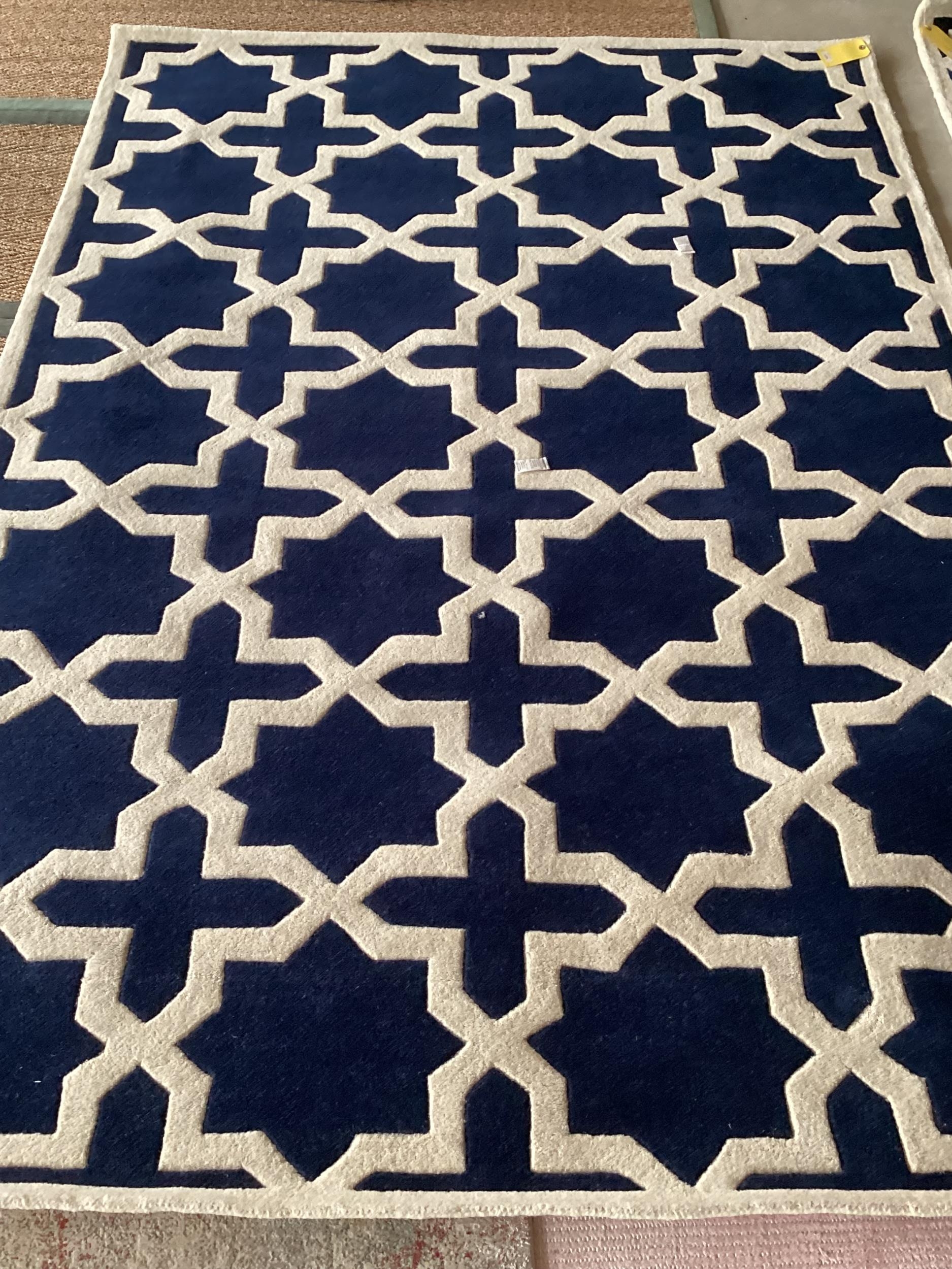 An excellent quality, as new, from original packaging, dark blue and ivory coloured Indian rug,
