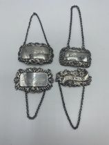 Four sterling silver decanter labels.