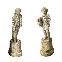 Two weathered garden statues, of two boys on circular plinth bases