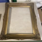 A good quality antique French Rococo style gilded wooden picture frame bearing old labels on reverse