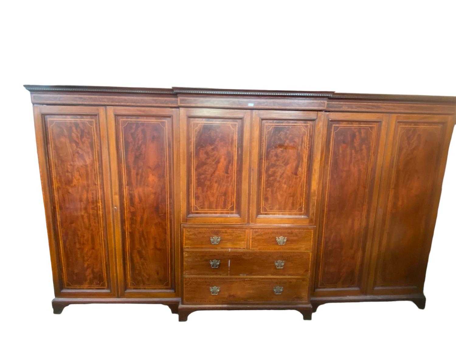 A good quality Edwardian breakfront three section compactum, central sections with four slides (