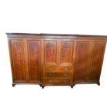 A good quality Edwardian breakfront three section compactum, central sections with four slides (