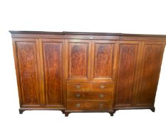 A good quality Edwardian breakfront three section compactum, central sections with four slides (