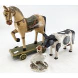 A carved model of a cow, a painted horse on wheels and a ceramic sheep posy vase