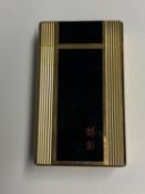 A Dupont gold plated and black enamel lighter with red Chinese calligraphy