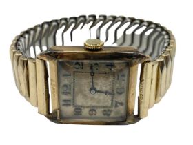 A 9ct gold cased gents watch, rectangular case with Roman numeral markers, on rolled gold strap,