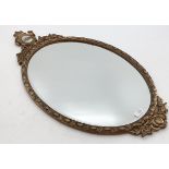 A gilt framed oval mirror, topped by inset ceramic oval panel, bevelled plate, 43-78cm