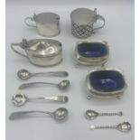 Collection of salts and mustards and spoons, and liners, one damaged. Various dates and makers.