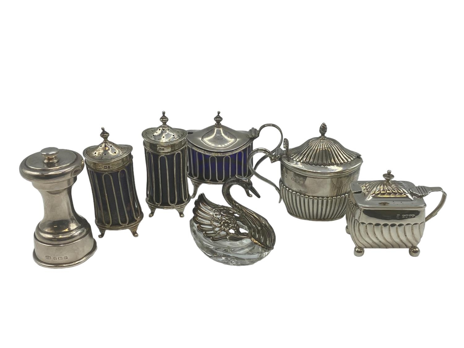 A collection of sterling silver table items to include a pair of Adams Style Pepperets, A pepper