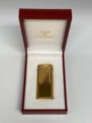 A Cartier Gold plated lighter in red tooled Cartier Box