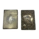 Two sterling silver card cases, one with a stag in a landscape, vacant cartouche, scrolling surround