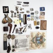A miscellaneous collection of items to include pipes, zipped lighters, military buttons and lapel