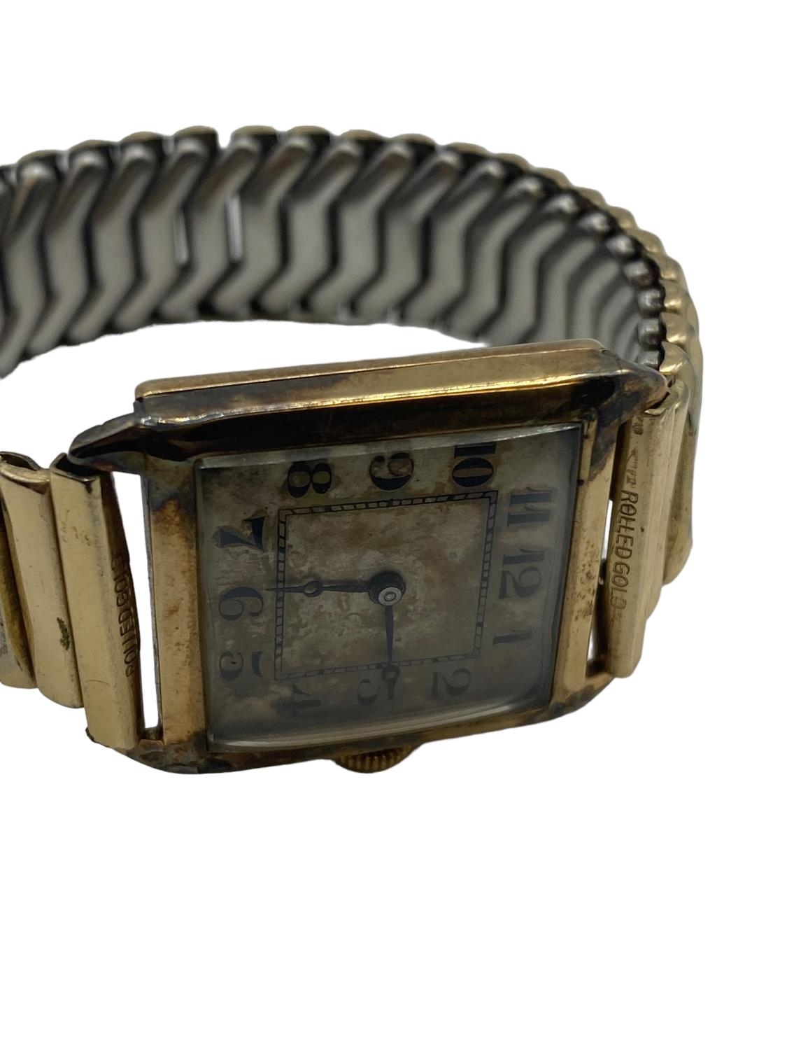 A 9ct gold cased gents watch, rectangular case with Roman numeral markers, on rolled gold strap, - Image 5 of 5