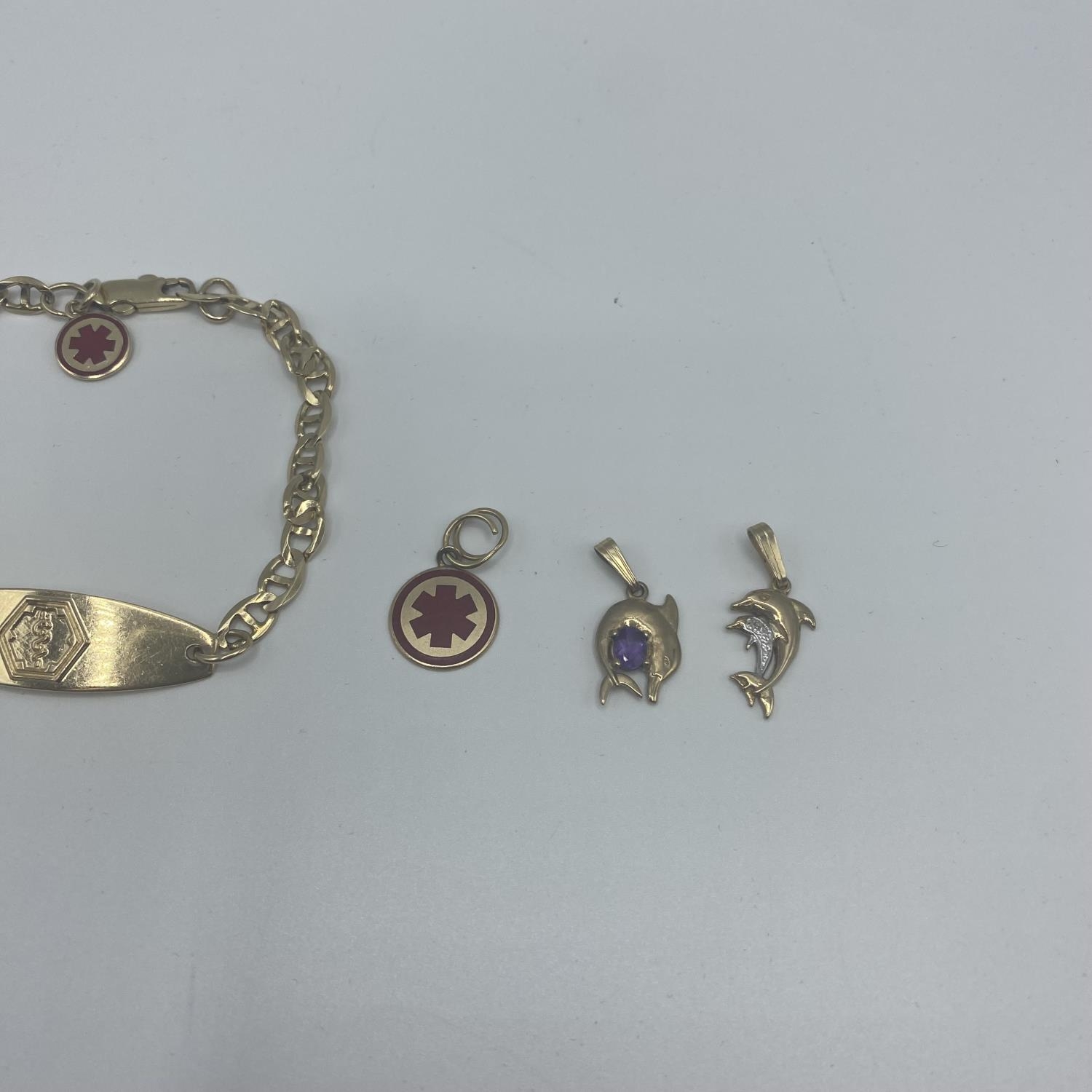 A 10ct gold marked ID bracelet with 9ct and 10ct charms 12.5g - Image 3 of 5