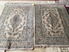 An excellent quality near pair of rugs, Persian, silk and wool, with beige ground and blue floral