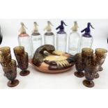 A set of moulded amber glasses together with vintage soda syphons and a ceramic lidded dish