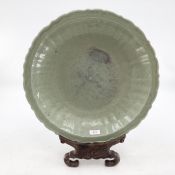 A large oriental Celadon charger on hardwood display stand, 44cm d