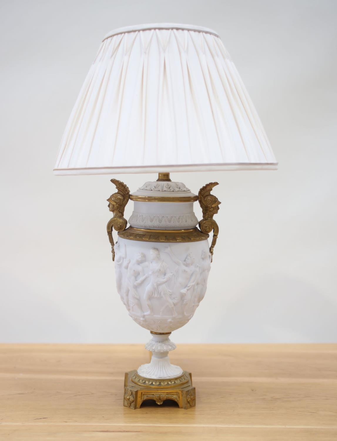 An Empire period biscuit porcelain urn with bas relief and solid brass mounts, as a table lamp,