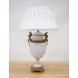 An Empire period biscuit porcelain urn with bas relief and solid brass mounts, as a table lamp,