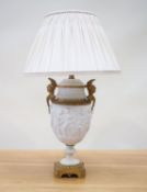 An Empire period biscuit porcelain urn with bas relief and solid brass mounts, as a table lamp,