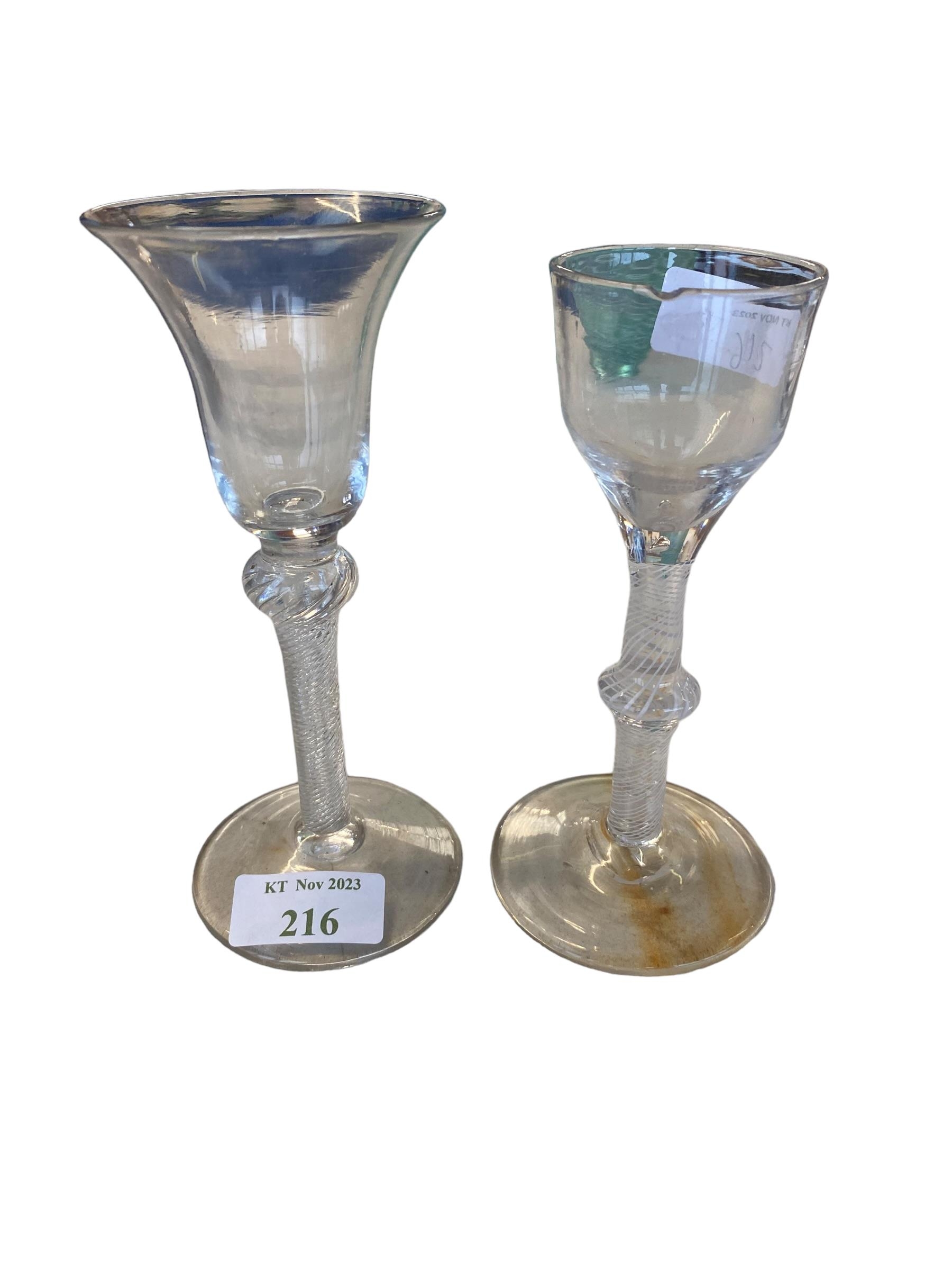 Two C18th spiral stem wine glasses, the smaller with chip to rim, 15 cm (tallest) and three later