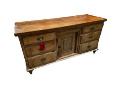 An antique pine sideboard, with 6 drawers flanking a central cupboard (back leg needs re-fixing);
