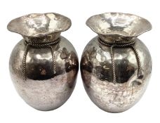 A pair of white metal vases of bulbous form flared rims with planished finish.19cm H