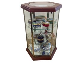 A small wooden glazed table top display stand, enclosed with shelves displaying 6 enamel pill boxes,
