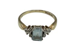 A 9 ct gold aquamarine and diamond chip dress ring, central Emerald cut aquamarine 5mm x 3.5 mm, 2.5