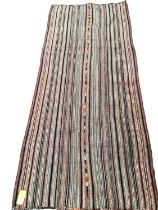 A Kilim style rug/runner with all over stylized reds and greys stripes, 133/310cm