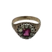 An unmarked yellow metal 18th century ruby and diamond dress ring. Central cushion cut ruby of