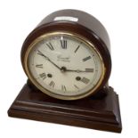 A wooden cased mantle clock, with cream dial and black Roman Numeral letters, marked makers name
