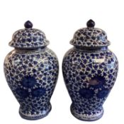 A decorative pair of blue and white ginger jars and covers, with all over leaf design, and Greek key