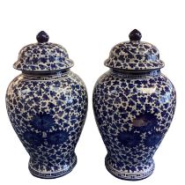 A decorative pair of blue and white ginger jars and covers, with all over leaf design, and Greek key