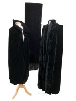 Two vintage black velvet capes, one with mark to shoulder and one with stains to lining and a velvet