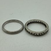 Two unmarked white metal rings. A diamond channel set diamond eternity ring together with a