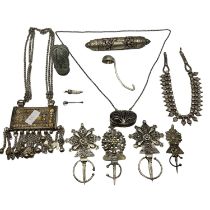 A collection of Omani style white metal jewellery, prayer scroll, decorative robe pins (7 items