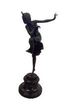 A bronze model of a female dancer with head-dress, raised on circular plinth base, marked to base