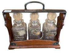 A mahogany cased tantallus, with patent stamp to side, and three hallmarked silver decanter