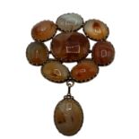 An unmarked yellow metal Scottish hardstone flower brooch set with 9 agate hardstones. 14.3g.