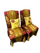 A pair of small decorative side chairs upholstered in a red and gold fabric