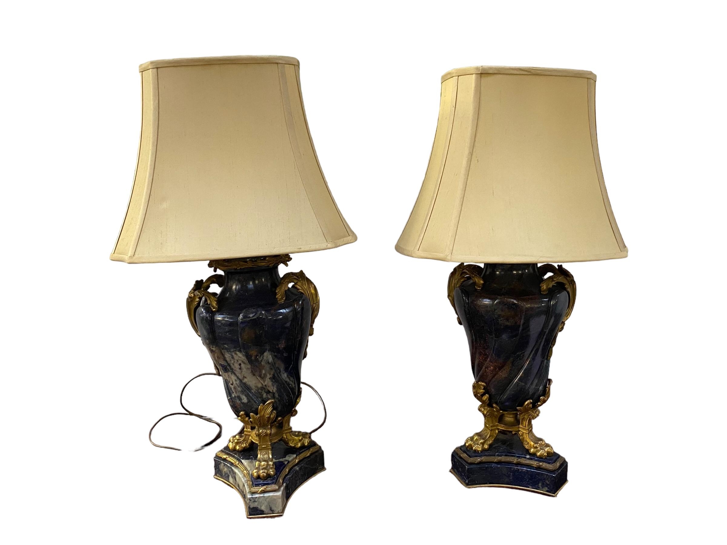 A pair of excellent quality carved hardstone and ormulu mounted table lamps with claw feet on