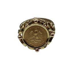 A coin signet ring. Mexican two peso coin in an unmarked yellow metal mount. 4.40g. Size K.