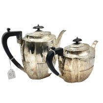 A sterling silver two piece tea set with half reeded design and ebonised handle. Approx 32ozt