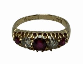 An 18 carat gold Ruby and diamond ring, 3 round free cut rubies set with two old cut diamonds, 3g