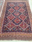 Kurdish wool rug with stylized central medalions and geometric borders, red and blue ground, 132cm x