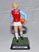 Bobby Moore. West Ham & England. Plastic figurine of Moore in West Ham colours with orange ball in